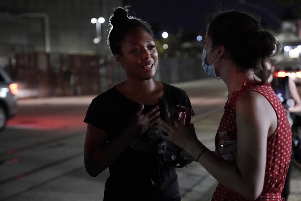 Adelana Akindes, left, reacts after being released from a day in police custody Thursday, Aug. 27, 2020, in Kenosha, Wis. Protesters gathered for a fifth night in reaction to the police shooting of Jacob Blake. (AP Photo/Morry Gash)