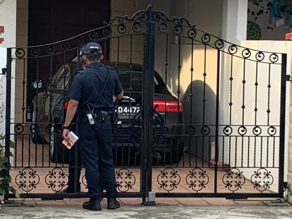 Two police officers at 7 Galistan Avenue, the premises used by Platinium Dogs Club for its pet boarding services. A woman who is said to be linked to Platinium is sitting inside the car, according to eyewitness Derrick Tan. PHOTO: Derrick Tan