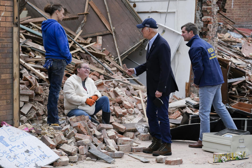 President Joe Biden and Kentucky Gov. Andy Beshear talk to people as they survey storm damage from tornadoes and extreme weather in Mayfield, Ky., Wednesday, Dec. 15, 2021. (AP Photo/Andrew Harnik)