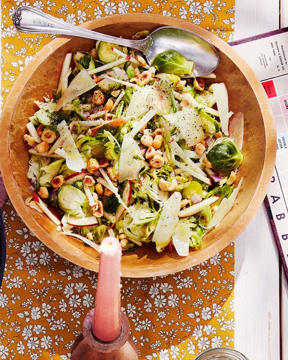 shaved brussels sprouts salad in a wooden bowl with silverware