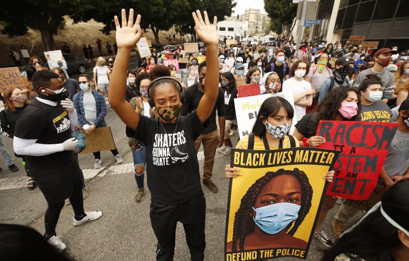 LOS ANGELES, CA - JUNE 23: Liliana Ruiz, left, and Jacqueline Ramirez, middle, join members of Black Lives Matter-Los Angeles and their supporters as they hold a demonstration outside LAUSD headquarters during the School Board Zoom meeting to demand that the Board of Education defund school police, reallocating funds to other student-serving initiatives. Los Angeles on Tuesday, June 23, 2020 in Los Angeles, CA. (Al Seib / Los Angeles Times)