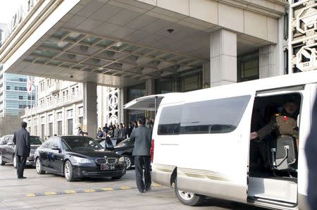 A North Korean man in military uniform (R) sits in a van of the Moranbong Band of North Korea walks out of a hotel with their instruments and luggage in central Beijing, China, December 12, 2015. REUTERS/Stringer