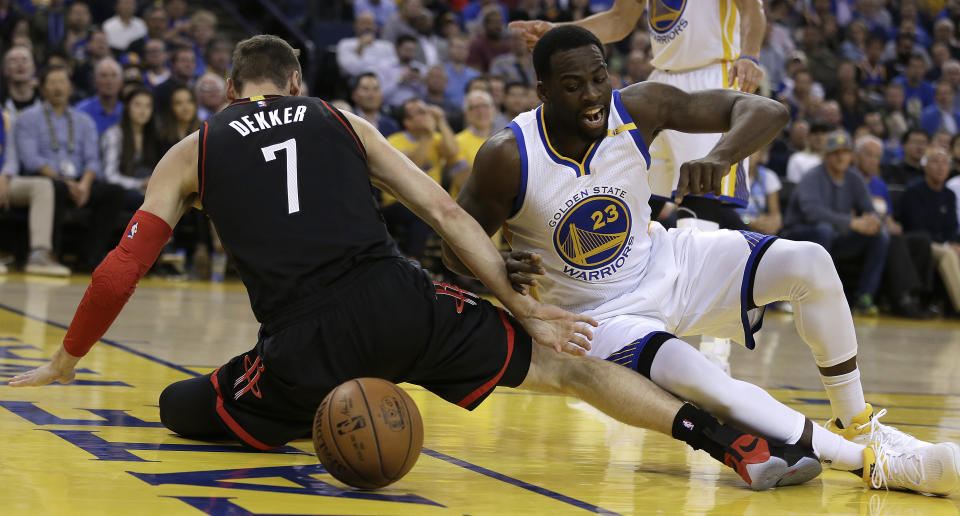 Los jugadores Sam Dekker (7) , de los Rockets de Houston, y Draymond Green, a la derecha, de los Warriors de Golden State, luchan por el balón durante la primera mitad de su juego NBA el viernes 31 de marzo de 2017, en Oakland, California. (AP Foto/Ben Margot)