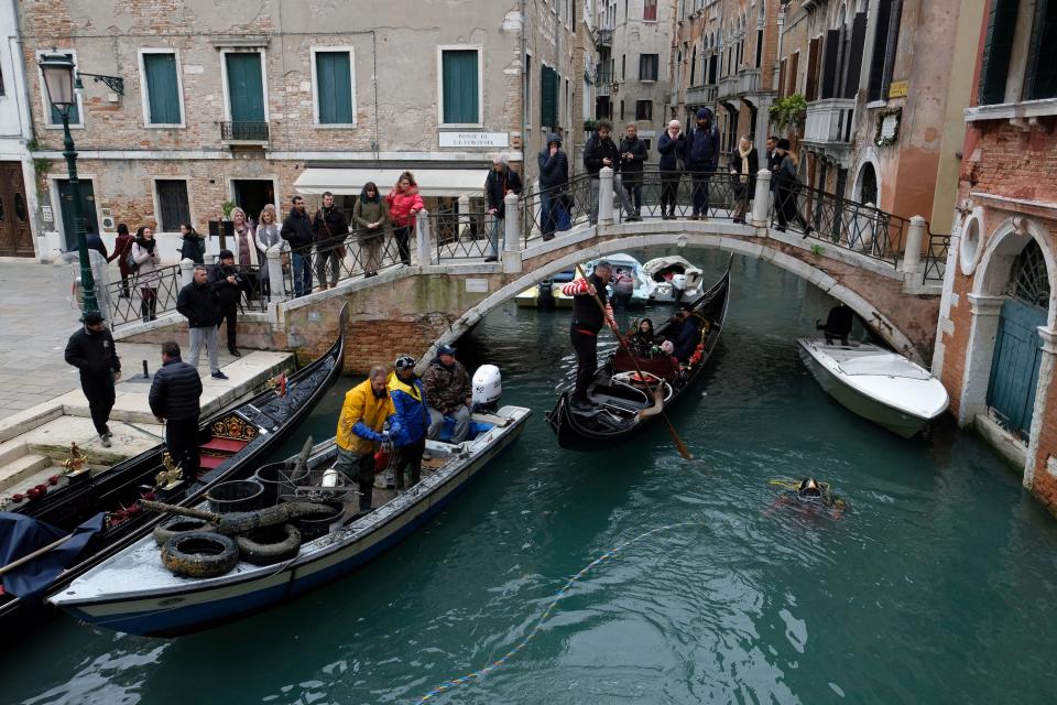 A group of scuba divers from Venice's gondolier association collect waste from the lagoon city's canals as part of a clean-up operation in Venice in December 2019.