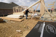 In this March 16, 2021 photo, a workman carries beamS at a new housing site in Madison County, Miss. Rising costs and shortages of building materials and labor are rippling across the homebuilding industry, which accounted for nearly 12% of all U.S. home sales in July. Construction delays are common, prompting many builders to pump the brakes on the number of new homes they put up for sale. As building a new home gets more expensive, some of those costs are passed along to buyers. (AP Photo/Rogelio V. Solis)