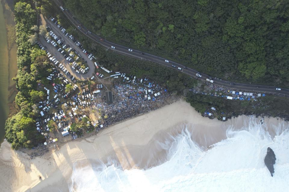 This aerial image provided by Clark Little shows the crowds gathered for the Eddie Aikau Big Wave Invitational surf competition at Waimea Bay, Hawaii, on Oahu’s North Shore, Sunday, Jan. 22, 2023. One of the world’s most prestigious and storied surfing contests is expected to be held Sunday in Hawaii for the first time in seven years. And this year, female surfers will be competing alongside the men for the first time in the 39-year history of The Eddie Aikau Big Wave Invitational. (Clark Little via AP)