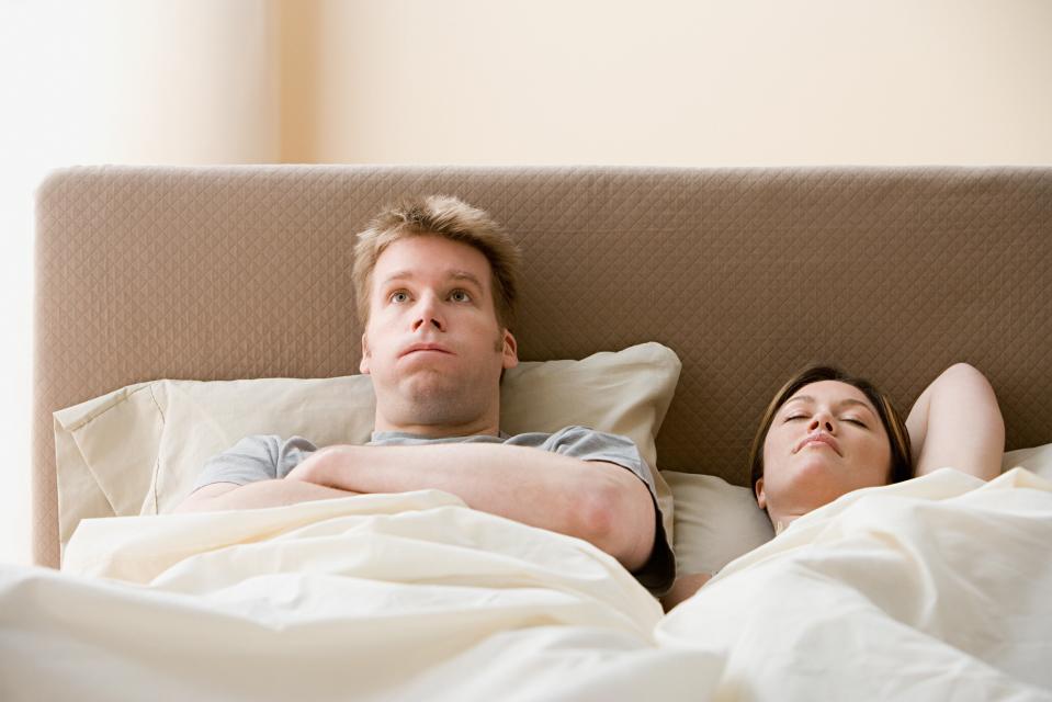 Frustrated man and sleeping woman