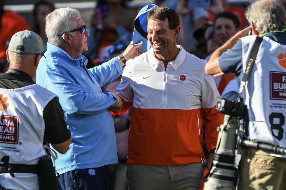 Nov 18, 2023; Clemson, South Carolina, USA; North Carolina Tar Heels head coach Mack Brown and Clemson Tigers head coach Dabo Swinney hug before kickoff at Memorial Stadium. Mandatory Credit: Ken Ruinard-USA TODAY Sports