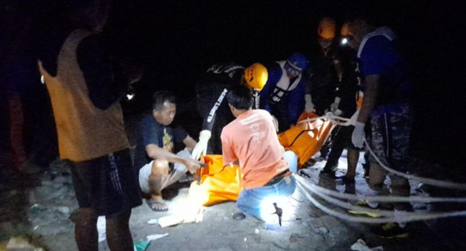 Bali rescuers at the sence placing the tourist's body in a bag on the beach. Source: Tabanan Police/Detiknews