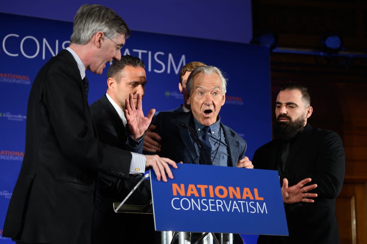 A heckler is dragged away after interrupting Jacob Rees-Mogg at the National Conservatism conference in London on Monday.  (Getty Images)