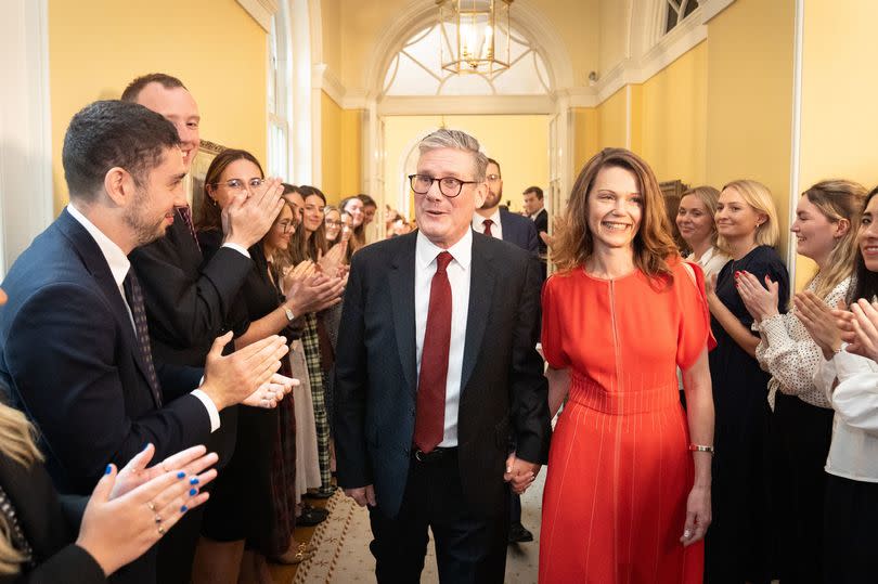 Newly elected Prime Minister Sir Keir Starmer with his wife Victoria Starmer are clapped in by staff as they enter his official London residence