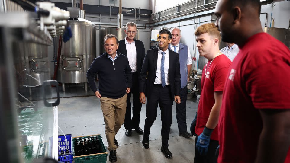 Sunak (center) is shown a bottling machine during a campaign visit to the Vale of Glamorgan Brewery in Barry, south Wales, on Thursday. - Henry Nicholls/AFP/Getty Images