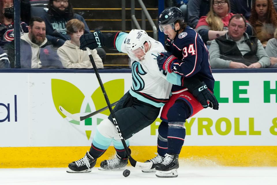 Mar 3, 2023; Columbus, Ohio, USA;  Columbus Blue Jackets center Cole Sillinger (34) fights for the puck wtih Seattle Kraken defenseman Vince Dunn (29) during the first period of the NHL hockey game at Nationwide Arena. Mandatory Credit: Adam Cairns-The Columbus Dispatch