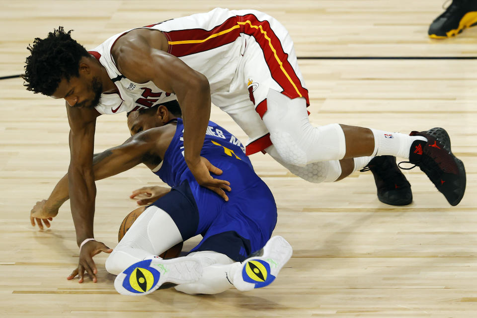 Denver Nuggets' Monte Morris, bottom, and Miami Heat's Jimmy Butler scramble for the ball during an NBA basketball game, Saturday, Aug. 1, 2020, in Lake Buena Vista, Fla. (Kevin C. Cox/Pool Photo via AP)