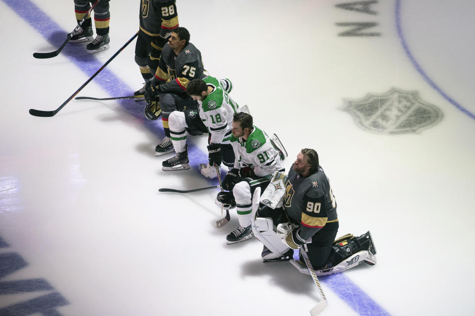 FILE - In this Aug. 3, 2020, file photo, Dallas Stars' Jason Dickinson (18), Tyler Seguin (91) and Vegas Golden Knights' Ryan Reaves (75) and goalie Robin Lehner (90) take a knee for Black Lives Matter during the national anthem prior to an NHL hockey playoff game in Edmonton, Alberta. Reaves, Lehner, Seguin and Dickinson became the first NHL players to kneel during the U.S. and Canadian anthems before a game they played in. (Jason Franson/The Canadian Press via AP, File)