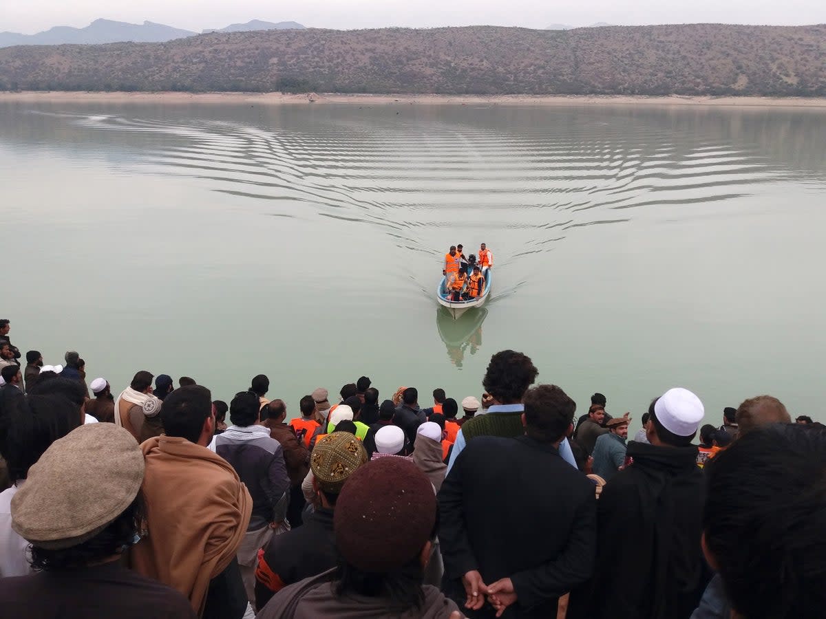 Rescue workers perform a search operation for bodies after a boat capsized in Kohat dam, Pakistan (EPA)