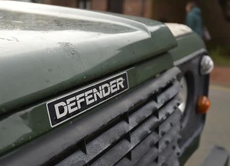 A woman walks past a Land Rover Defender parked on a street in London, Britain, January 29, 2016. REUTERS/Toby Melville