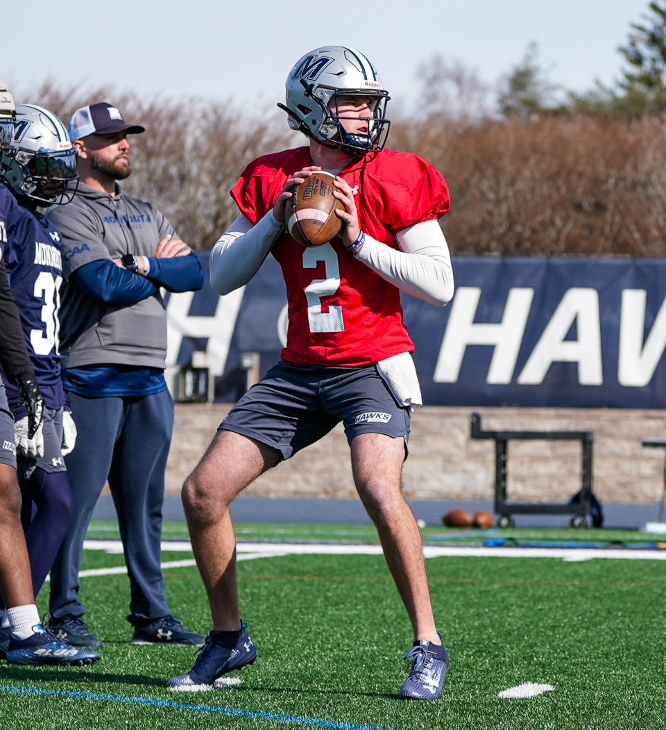 Monmouth quarterback Derek Robertson, with his brother, Jimmy Robertson, the Hawks' passing game coordinator and quarterback coach, looking on during spring practice in West Long Branch, N.J. on March 26, 2024.