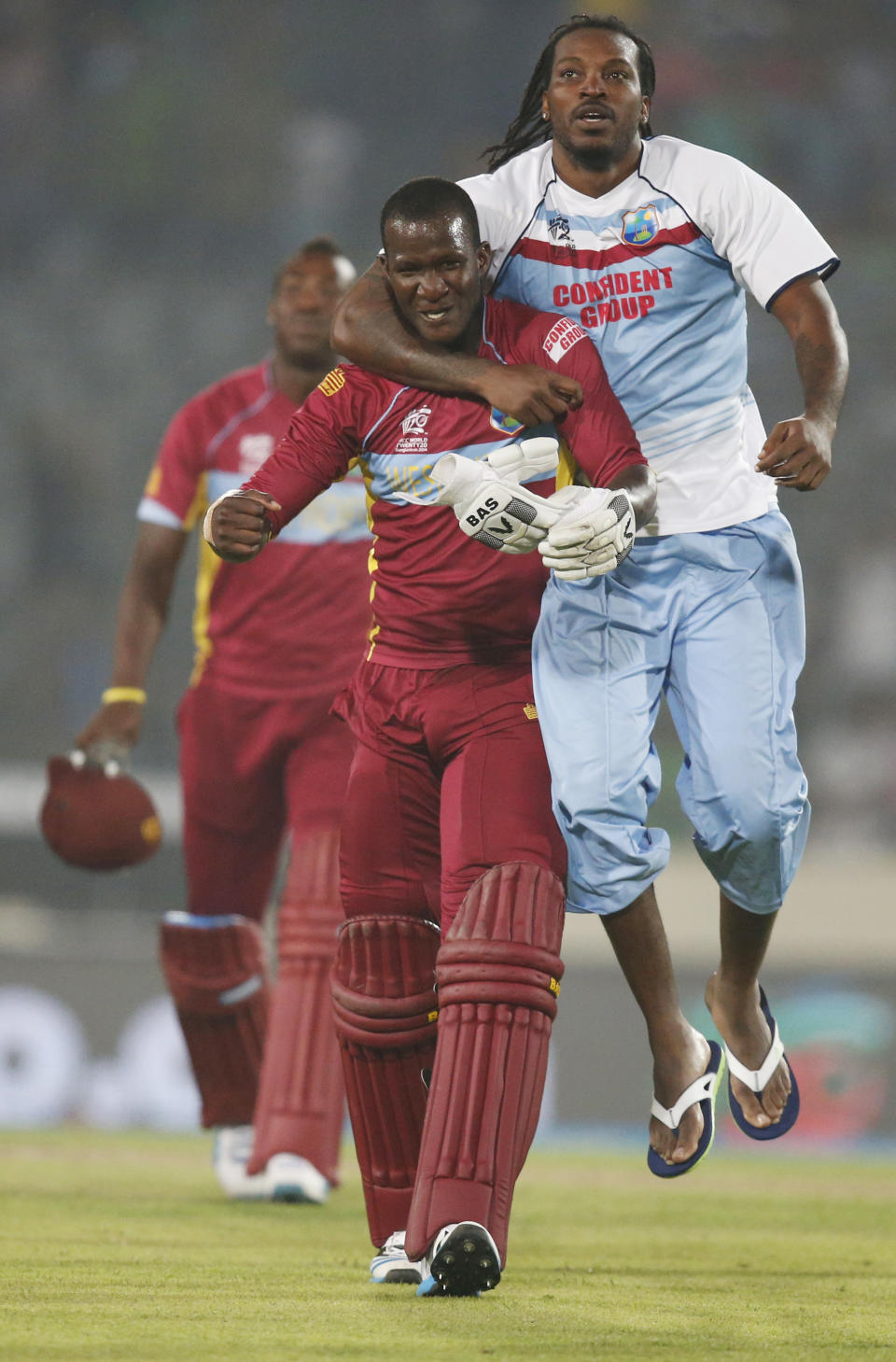 West Indies' captain Darren Sammy, center, and teammate Chris Gayle, right, celebrate their win over Australia in the ICC Twenty20 Cricket World Cup match in Dhaka, Bangladesh, Friday, March 28, 2014. West Indies' won the match by six wickets. (AP Photo/Aijaz Rahi)