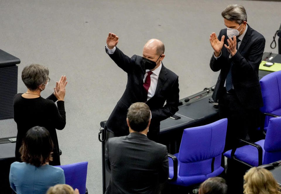 Olaf Scholz of the Social Democrats, center, waves after he was elected new German Chancellor in the German Parliament Bundestag in Berlin, Wednesday, Dec. 8, 2021. The election and swearing-in of the new Chancellor and the swearing-in of the federal ministers of the new federal government will take place in the Bundestag on Wednesday. (Photo/Markus Schreiber)