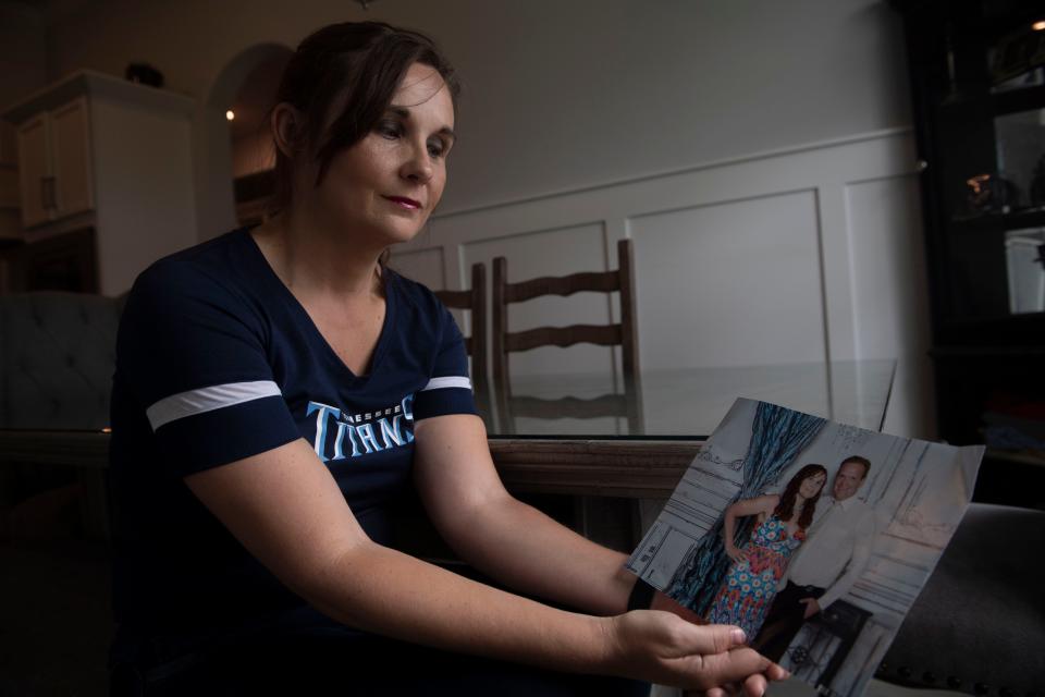 Tracie Hirschler, sits in her kitchen holding a photograph of her and her husband, in Murfreesboro, Tenn., Friday, Aug. 11, 2023.