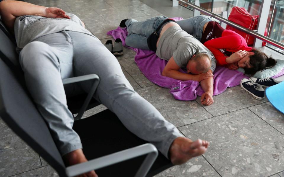 People sleep at Heathrow Terminal 5 after British Airways cancelled all flights from Heathrow and Gatwick - REUTERS