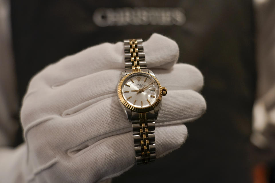 A member of staff holds a Rolex watch, as part of The Pattie Boyd Collection at Christie's, in London, Thursday, March 14, 2024. The watch is estimated to sell £2,500-4,000. (AP Photo/Alberto Pezzali)
