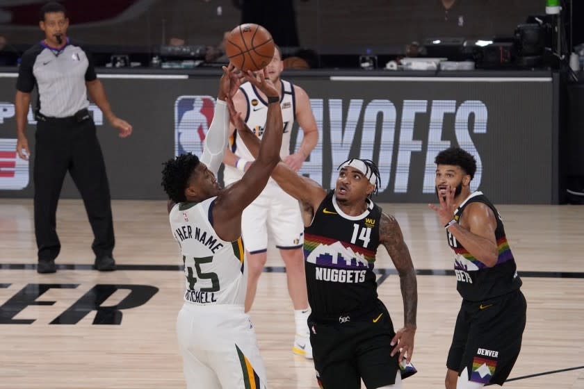 Utah Jazz's Donovan Mitchell (45) attempts a shot over Denver Nuggets' Gary Harris.