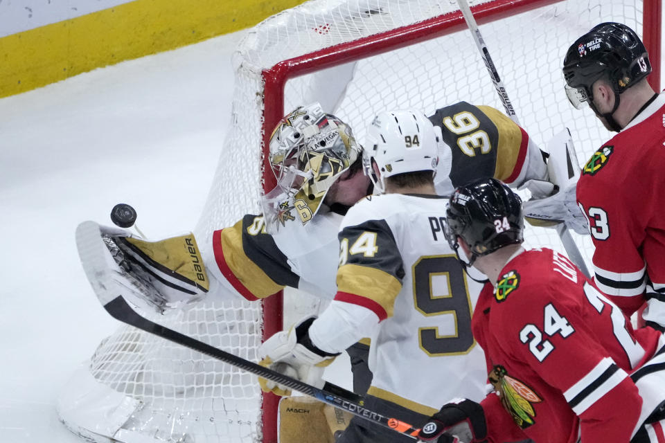 Vegas Golden Knights goaltender Logan Thompson (36) knocks the puck away from the goal with is glove hand during the third period of an NHL hockey game Thursday, Dec. 15, 2022, in Chicago. The Golden Knights won 4-1. (AP Photo/Charles Rex Arbogast)