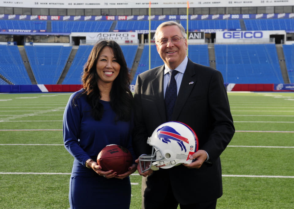 Kim, left, and Terry Pegula are introduced as the new owners of the Buffalo Bills as they pose for members of the media on the football field at Ralph Wilson Stadium in Orchard Park, N.Y., Friday, Oct. 10, 2014. (AP Photo/Gary Wiepert)