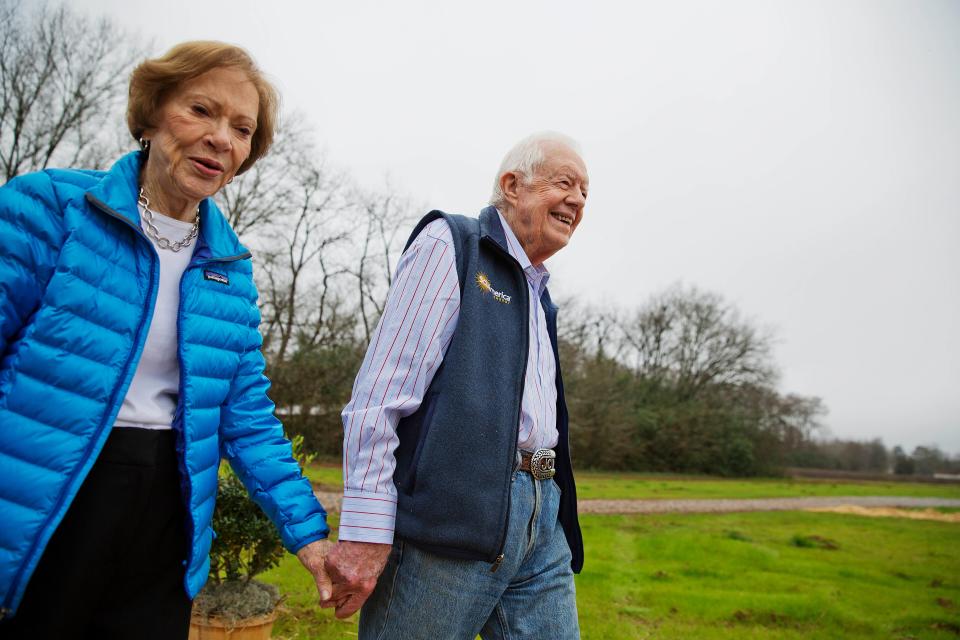 FILE: In this Feb. 8, 2017, file photo former President Jimmy Carter, right, and his wife Rosalynn arrive for a ribbon cutting ceremony for a solar panel project on farmland he owns in their hometown of Plains, Ga. Carter was an early investor in solar panel research as president.