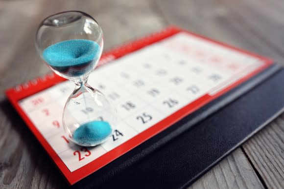 Image of an hourglass sitting on top of a calendar.