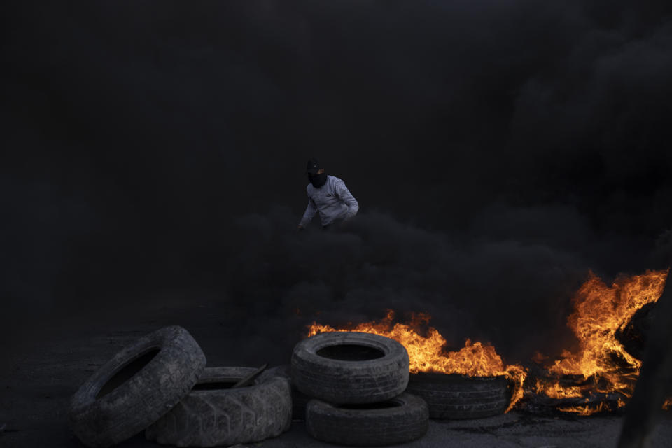 Palestinian protesters block the main road with burning tires in the West Bank city of Jericho, Monday, Feb. 6, 2023. Israeli forces killed five Palestinian gunmen in a raid on refugee camp in the occupied West Bank on Monday, the latest bloodshed in the region that will likely further exacerbate tensions.(AP Photo/Nasser Nasser)