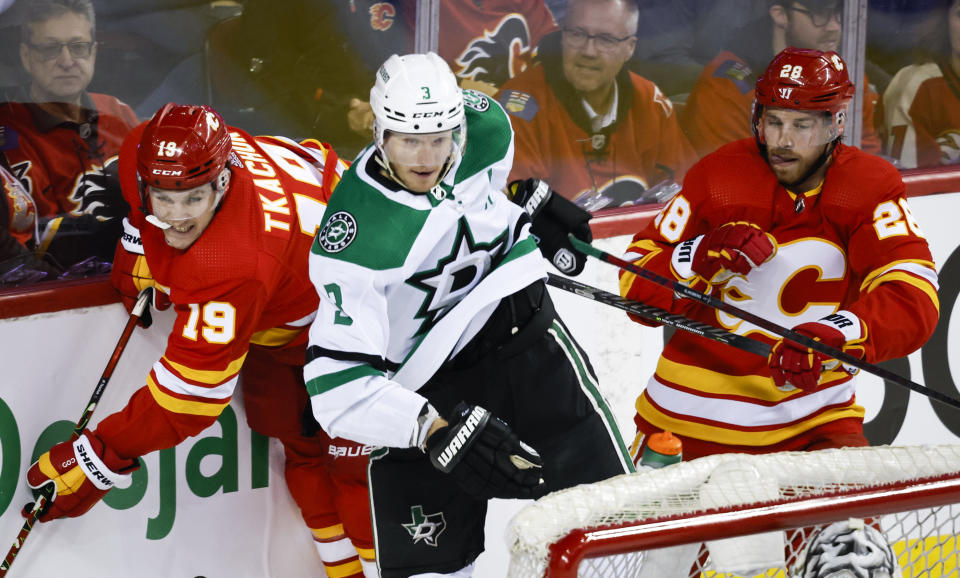 Dallas Stars defenseman John Klingberg (3) checks Calgary Flames left wing Matthew Tkachuk (19) as Flames center Elias Lindholm (28) watches during the first period of Game 1 of an NHL hockey first-round playoff series Tuesday, May 3, 2022, in Calgary, Alberta. (Jeff McIntosh/The Canadian Press via AP)