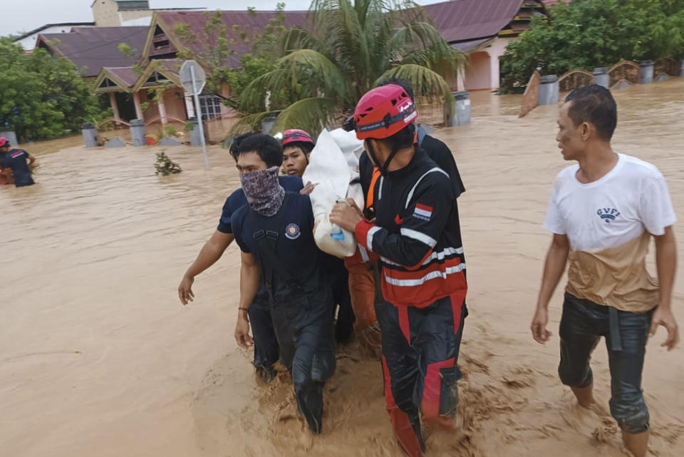 <strong>救援隊涉水抬著一名洪水受害者。（圖／美聯社）</strong>