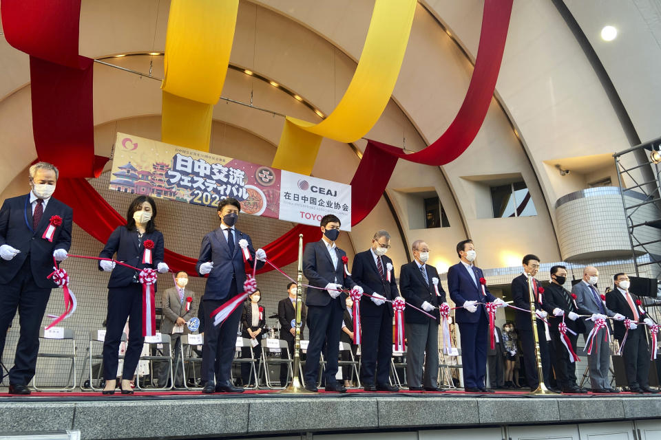 Organizers and guests participate in a ribbon-cutting ceremony during the annual Japan-China Exchange Festival at Tokyo's Yoyogi Park in Tokyo on Saturday, Sept. 24, 2022, marking the opening of the two-day friendship event and also marking the 50th anniversary of the Sept. 29, 1972, normalization of the ties between the two countries. The festival, after a two-year hiatus due to the COVID-19 pandemic, was back last weekend ahead of this week’s 50th anniversary of the normalizing of relations between the two Asian neighbors and economic powerhouses. (AP Photo/Mari Yamaguchi)