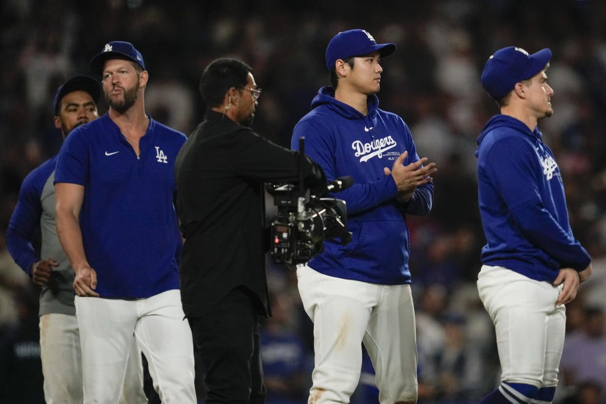 Los Angeles Dodgers designated hitter Shohei Ohtani, second from right, celebrates after a 6-4 win over the Colorado Rockies in a baseball game in Los Angeles, Friday, Sept. 20, 2024. (AP Photo/Ashley Landis)