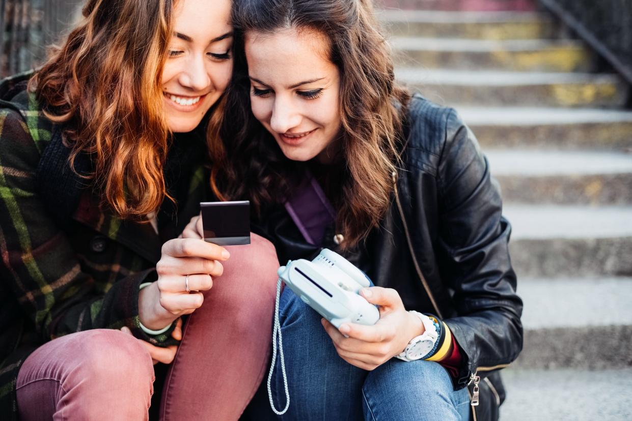 young women making instant photos with instant camera