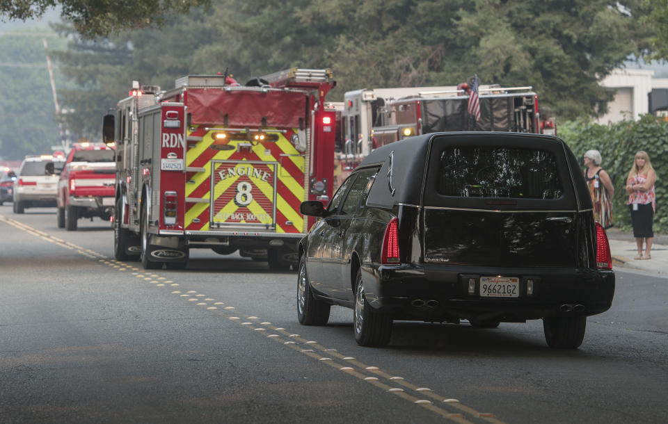 A procession for Redding fire inspector Jeremy Stoke passes in Redding, Calif., Thursday, Aug. 2, 2018. Stoke, who died last week in the Carr Fire, was being taken from the coroner's office to a funeral home. Fire officials say a massive blaze in Northern California that has killed six people and torched more than 1,000 homes grew overnight, fueled by wind. The California Department of Forestry and Fire Protection said Thursday firefighters made some gains and the blaze is now a third contained. (AP Photo/Michael Burke)
