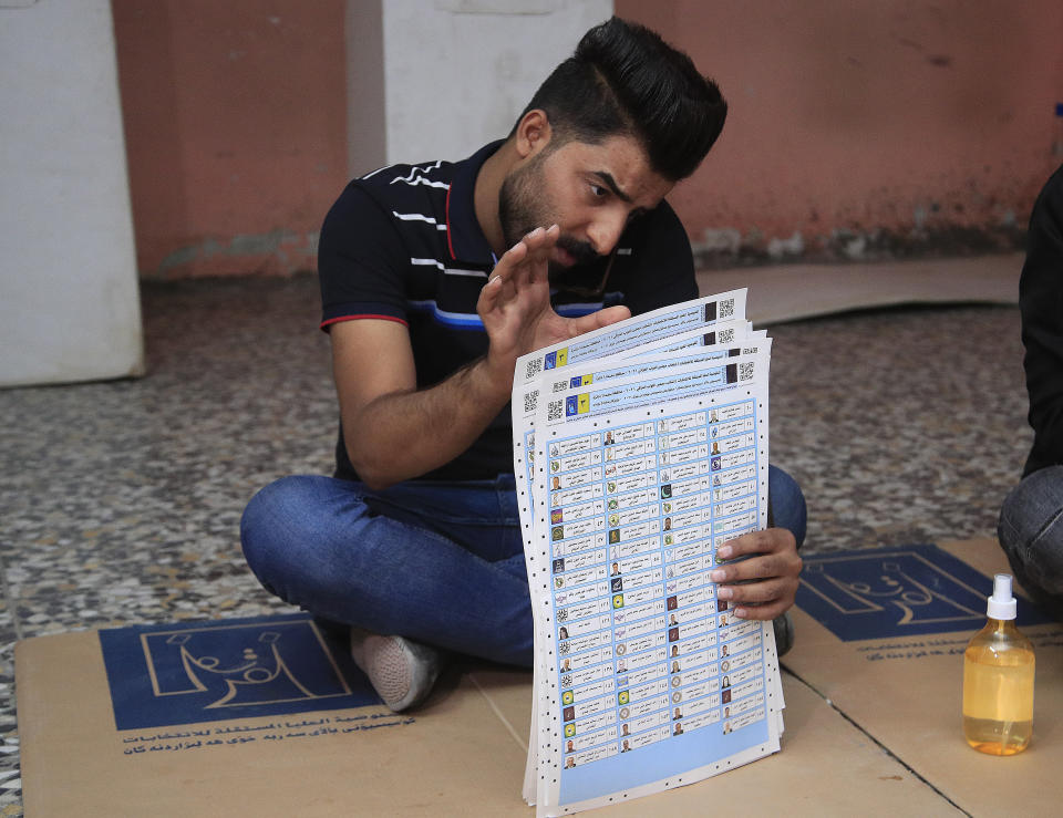 An election worker counts ballots after polls close, at a polling station in Baghdad, Iraq, Sunday, Oct. 10, 2021. Polls have closed across Iraq Sunday evening in parliamentary elections that were held months ahead of schedule in response to a popular uprising against corruption and mismanagement. (AP Photo/Hadi Mizban)