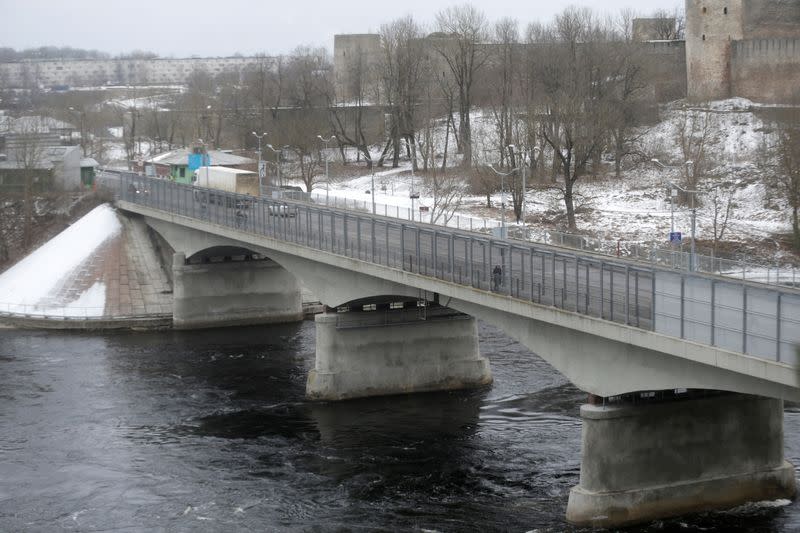 FILE PHOTO: People walk on the bridge over Narva river at the border crossing point with Russia in Narva