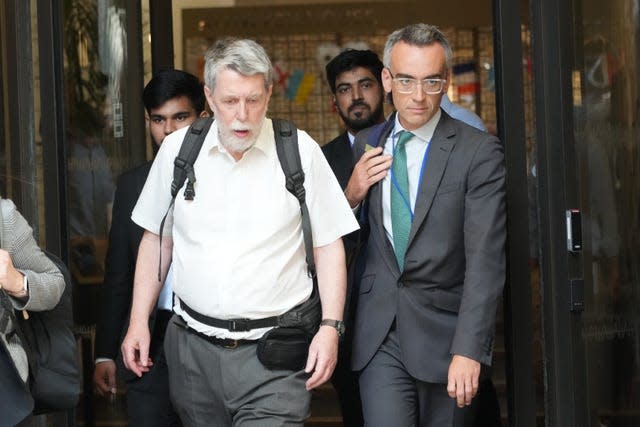 Gareth Jenkins leaves the inquiry building flanked by a man in a suit