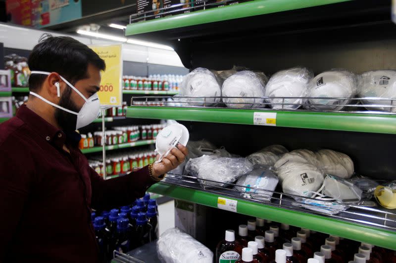 An Iraqi man wears protective mask, following the outbreak of the coronavirus, as he looks at face masks at a supermarket in Baghdad