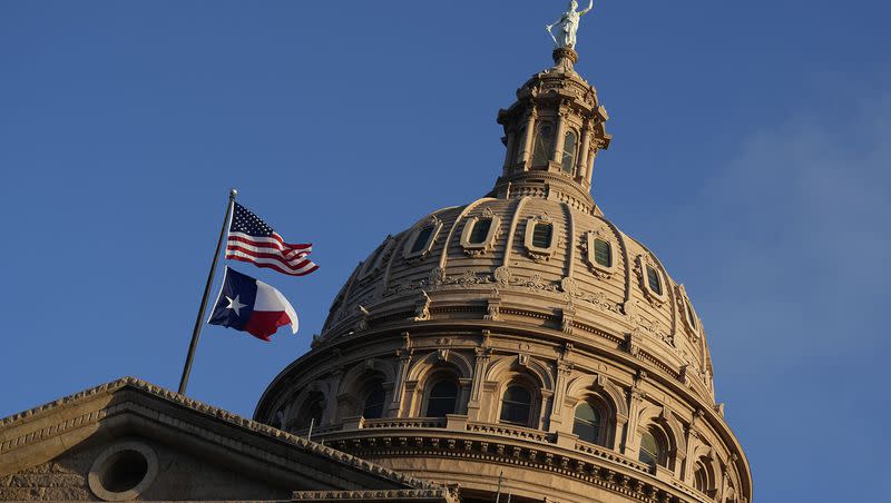 The U.S. and Texas flags fly over the Texas Capitol during the first day of the 88th Texas Legislative Session in Austin, Texas, on Jan. 10, 2023. A new in Texas would allow school districts to use security funds to hire uncertified chaplains due to a school counselor shortage. 