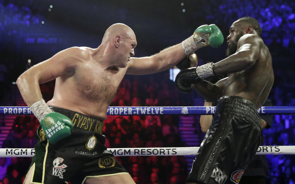 Tyson Fury, left, of England, fights Deontay Wilder during a WBC heavyweight championship boxing match Saturday, Feb. 22, 2020, in Las Vegas. (AP Photo/Isaac Brekken)