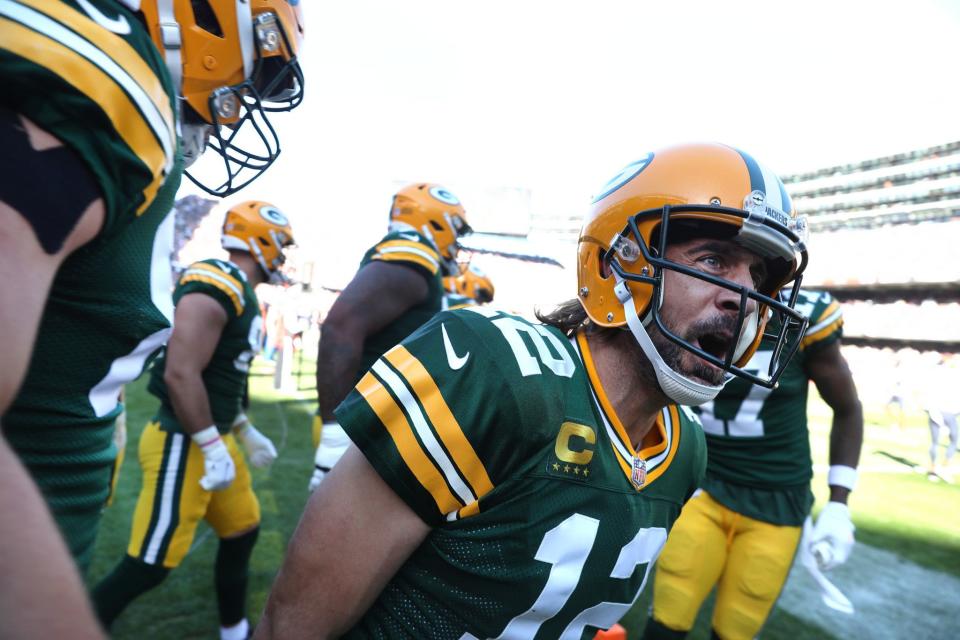 Green Bay Packers quarterback Aaron Rodgers celebrates with his teammates after rushing for a touchdown in the fourth quarter against the Chicago Bears at Soldier Field.