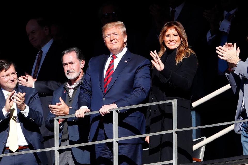 President Donald Trump watches the first half of an NCAA football game between Alabama and LSU with first lady Melania Trump on Saturday.