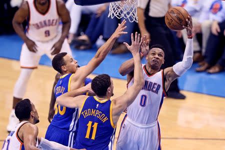 May 24, 2016; Oklahoma City, OK, USA; Oklahoma City Thunder guard Russell Westbrook (0) shoots as Golden State Warriors guard Klay Thompson (11) and guard Stephen Curry (30) defend in game four of the Western conference finals of the NBA Playoffs at Chesapeake Energy Arena. Mandatory Credit: Kevin Jairaj-USA TODAY Sports