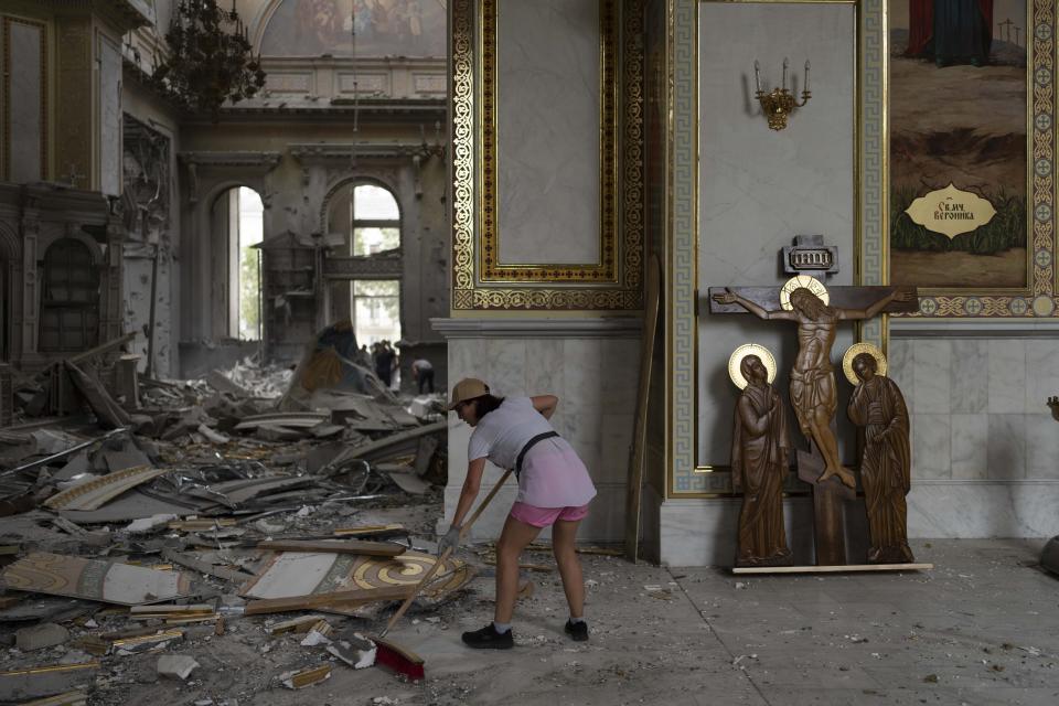 Los ucranianos limpian los escombros en la histórica Catedral de la Transfiguración. (AP Photo/Jae C. Hong)