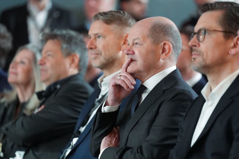 German Chancellor Olaf Scholz (2nd from R) sits among the guests and listens to a speech before the start of construction of the Northvolt factory, which will produce battery cells for electric cars from 2026. Marcus Brandt/dpa